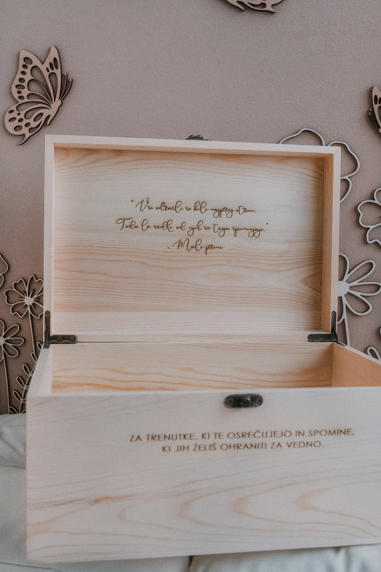 Notranjost pokrova škatle na katerem je graviran verz malega princa