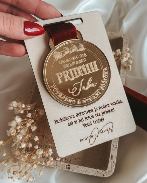 Medal with a tag held by a hand on a white fabric background